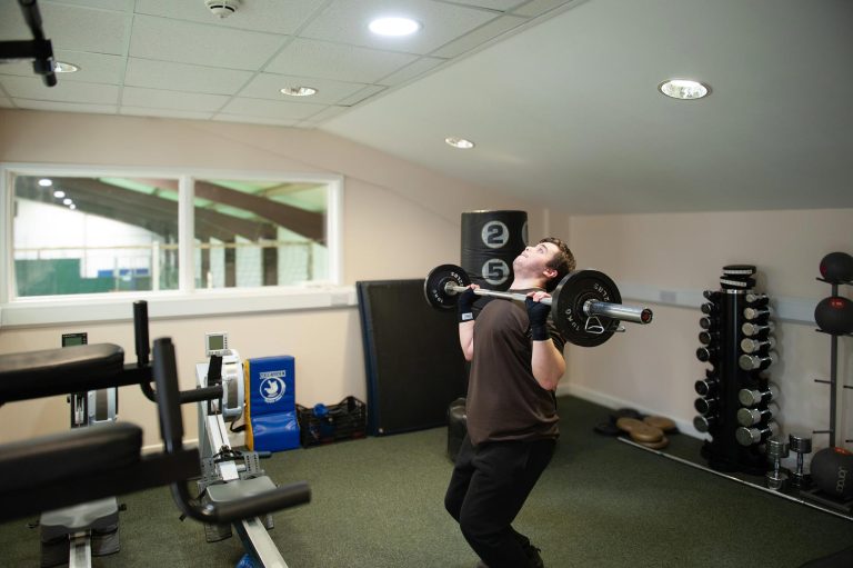 A pupil lifts a barbell