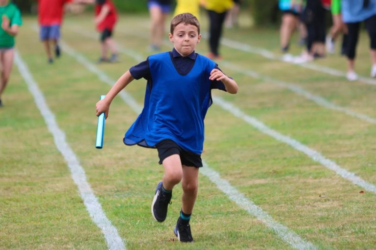 A child runs with a relay batton