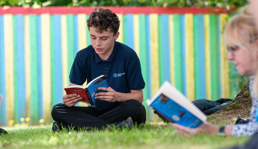 A pupil reads a book outside