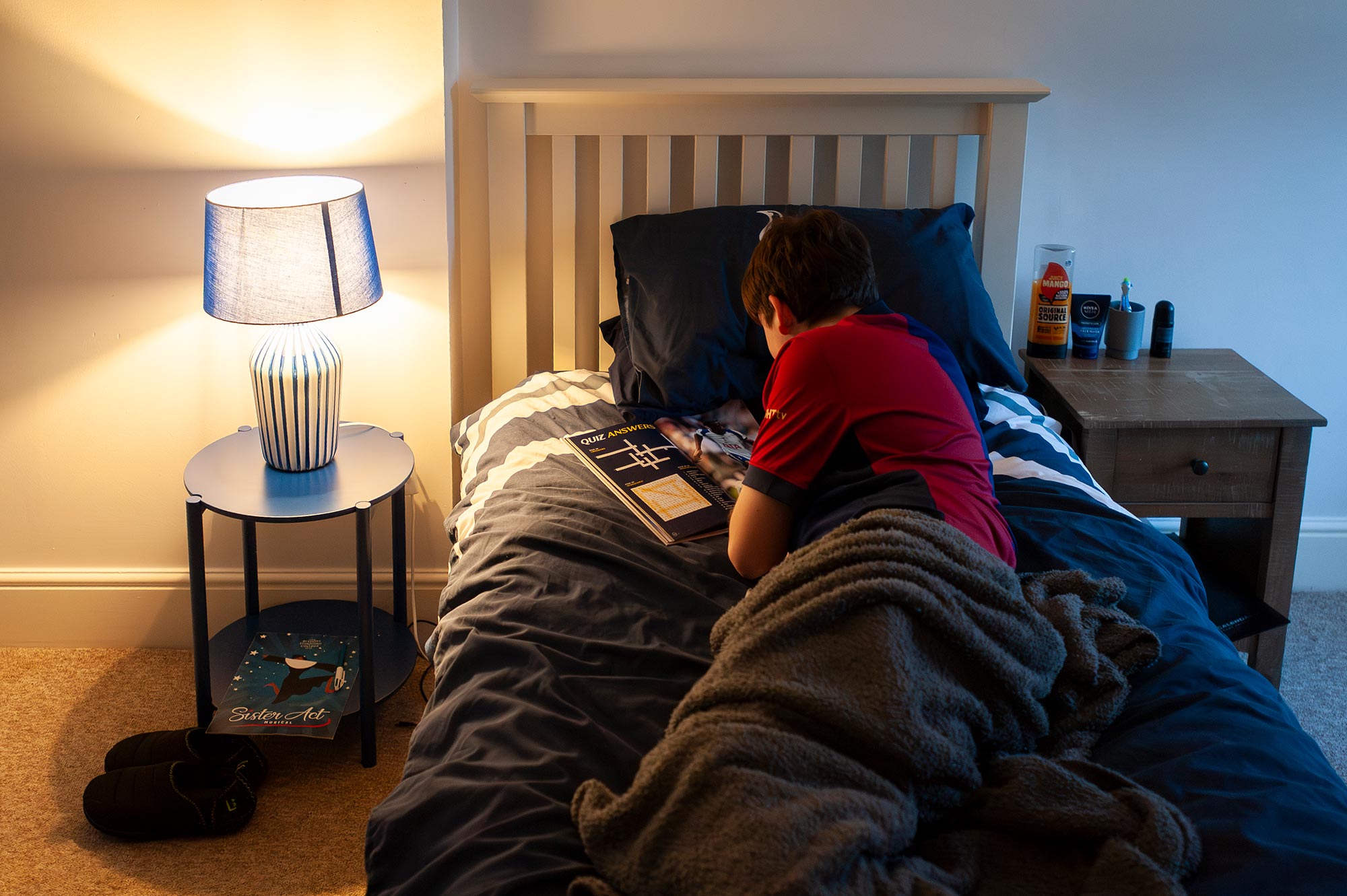 A pupil reads in a bed in a boarding house