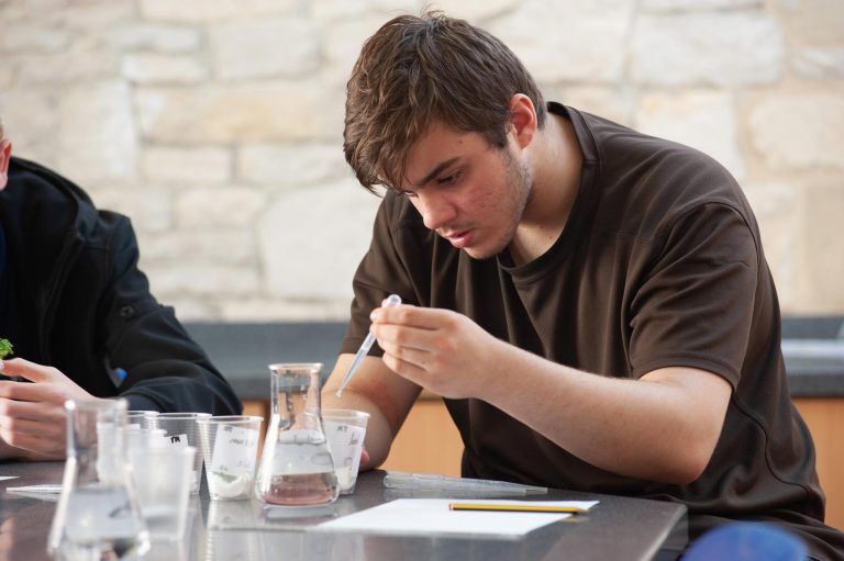 A pupil uses a pipette in a science class